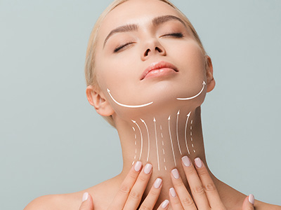 A woman with a serene expression is shown close-up, looking upwards with her eyes closed, while a facial mask is applied to her face.