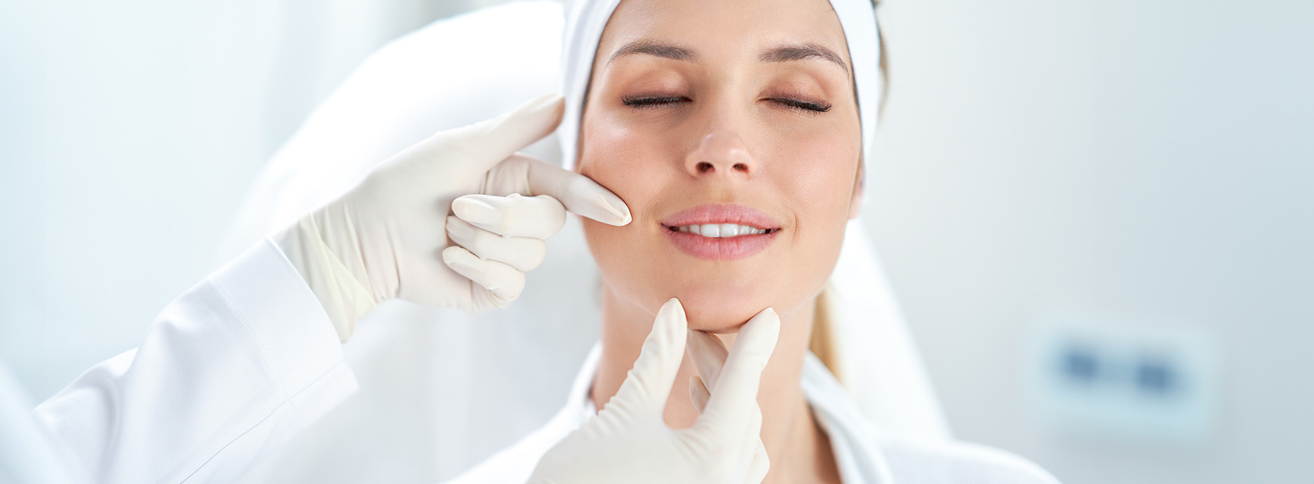 Woman receiving facial treatment from a medical professional in a clean, sterile environment.