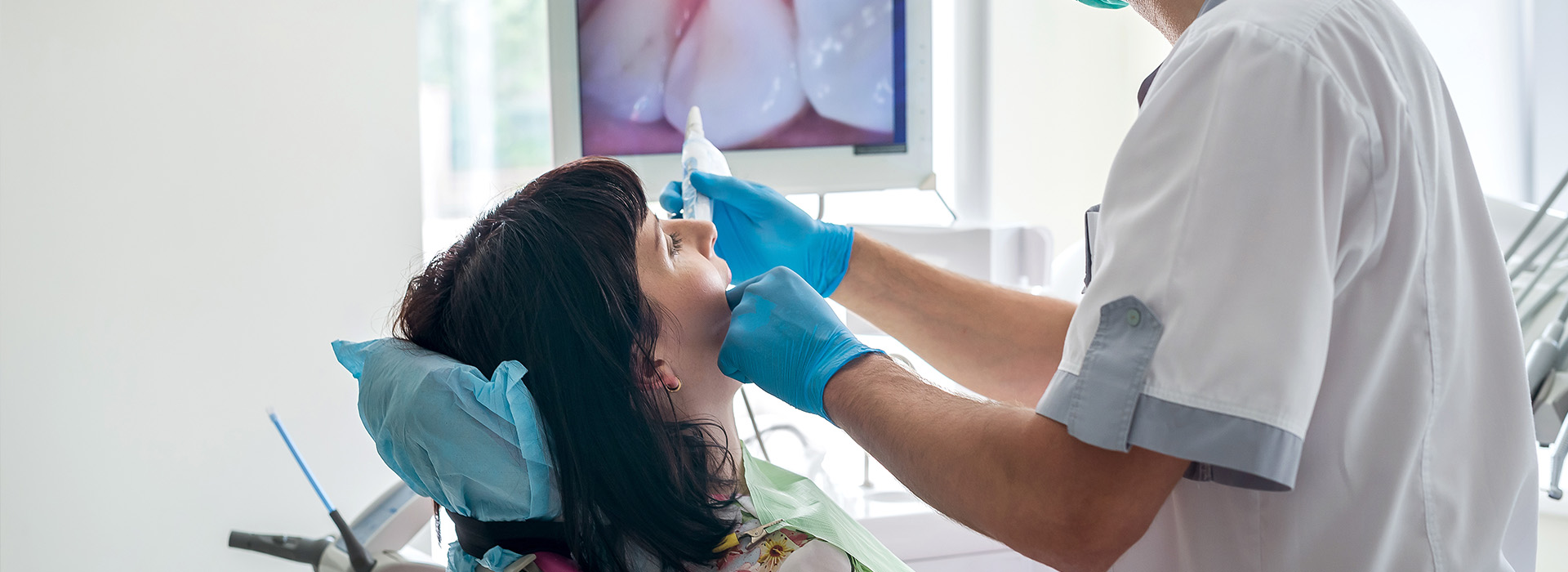 A dental hygienist performing a teeth cleaning procedure on a patient.
